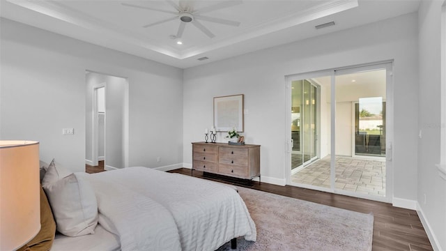 bedroom with access to exterior, a tray ceiling, ceiling fan, ornamental molding, and dark hardwood / wood-style floors