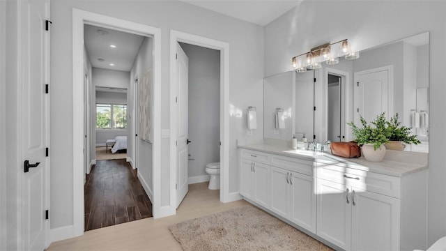 bathroom with hardwood / wood-style flooring, vanity, and toilet