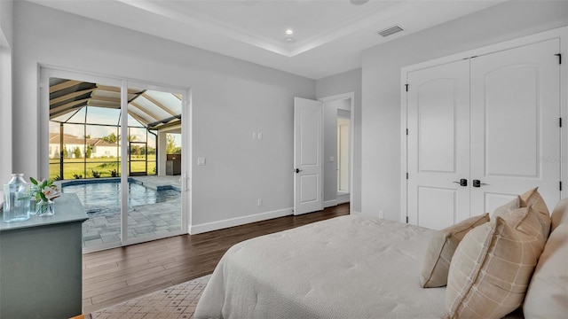 bedroom featuring access to outside, lofted ceiling, dark hardwood / wood-style flooring, and a closet