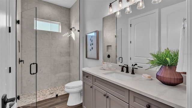 bathroom with vanity, walk in shower, hardwood / wood-style floors, and toilet