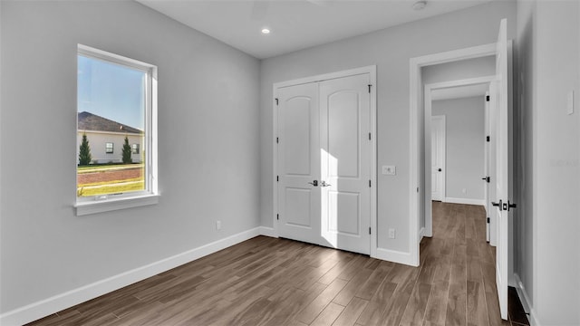 1529 Rio Vista Ter, Parrish, FL 34219 - unfurnished bedroom with baseboards, multiple windows, and wood finished floors