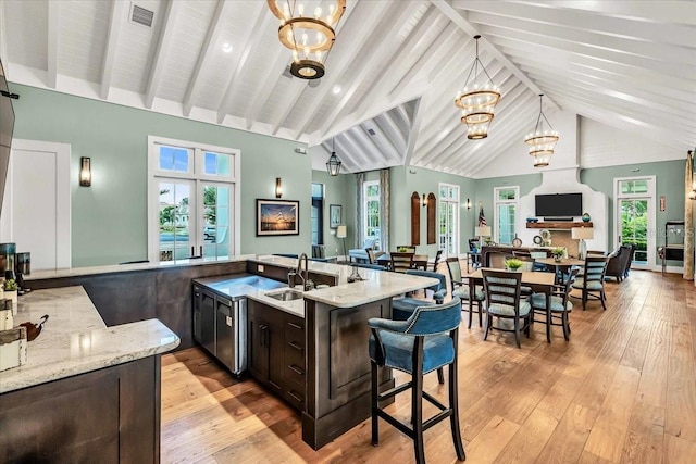 kitchen with hanging light fixtures, high vaulted ceiling, and plenty of natural light