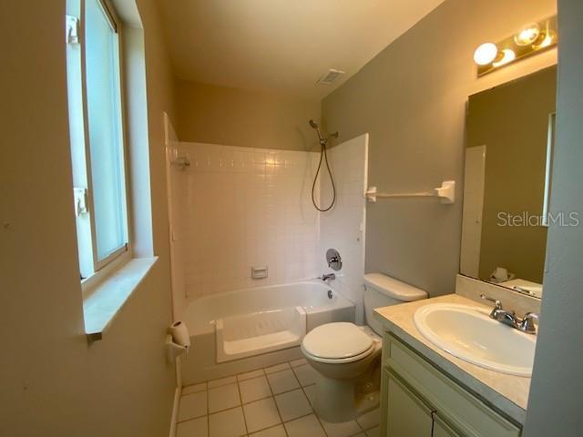 full bathroom featuring vanity, tile patterned flooring, washtub / shower combination, and toilet