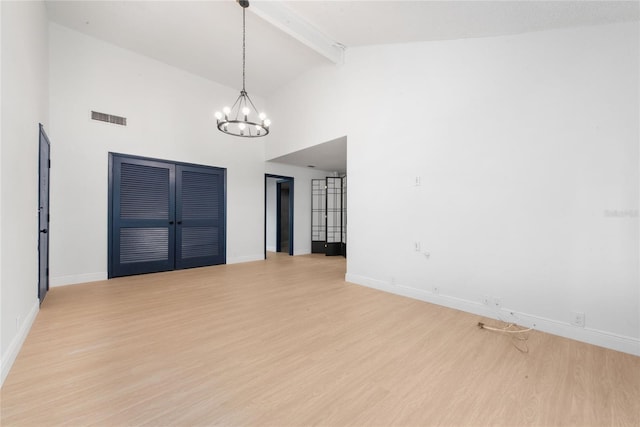 interior space with beamed ceiling, light wood-type flooring, high vaulted ceiling, and a chandelier