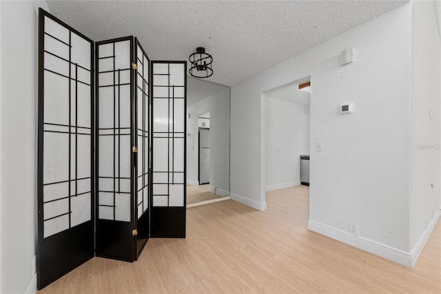 interior space with a textured ceiling and light wood-type flooring