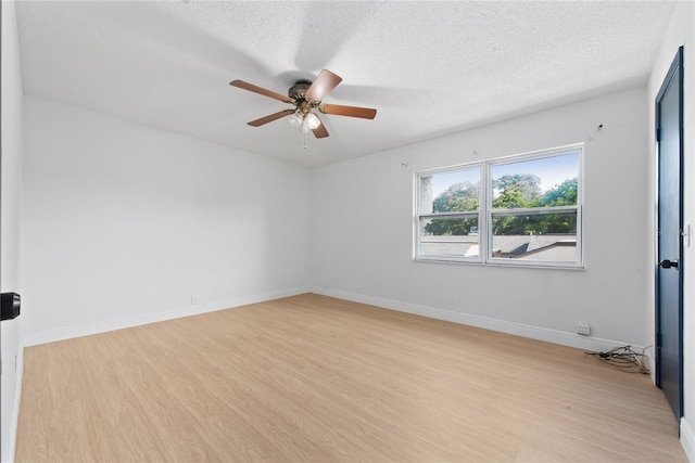 spare room featuring a textured ceiling, light wood-type flooring, and ceiling fan