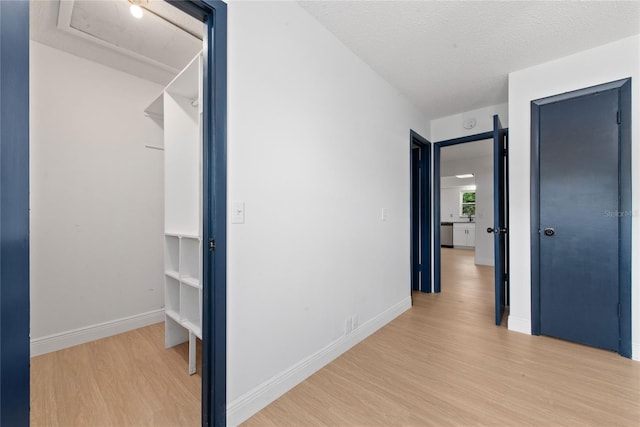 hall featuring a textured ceiling and light hardwood / wood-style floors