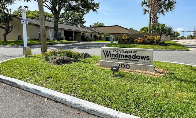 community / neighborhood sign featuring a lawn