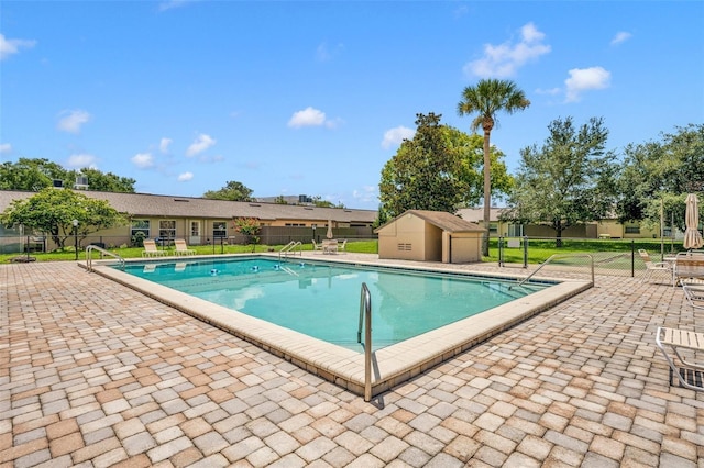 view of pool with an outbuilding and a patio area