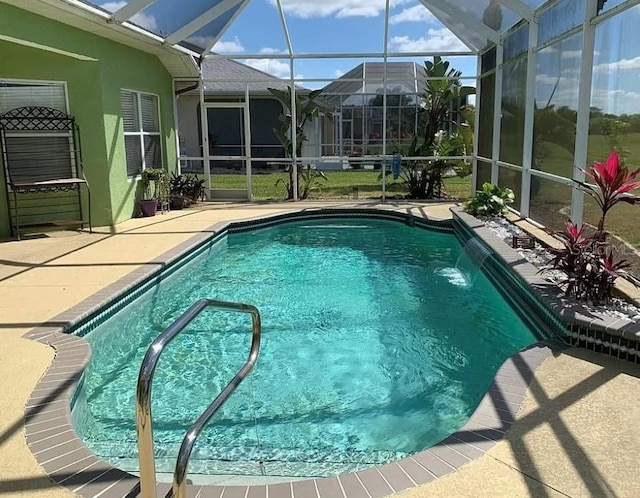 view of pool with a lanai, pool water feature, and a patio