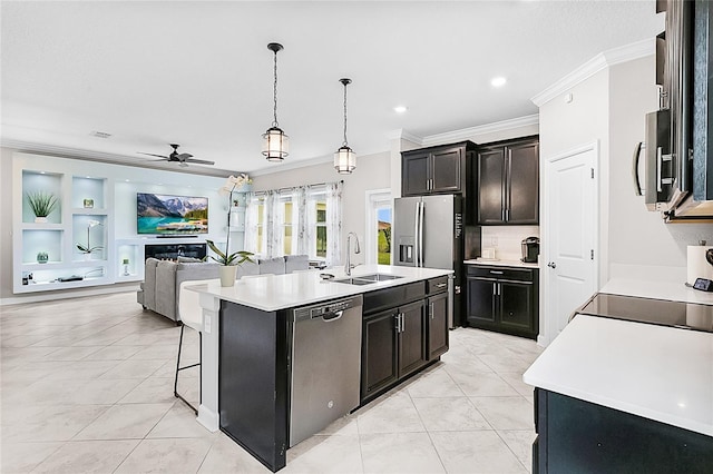 kitchen with appliances with stainless steel finishes, sink, decorative light fixtures, an island with sink, and ceiling fan