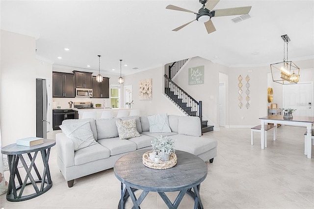 tiled living room featuring crown molding and ceiling fan with notable chandelier