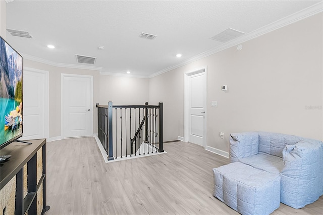 sitting room featuring crown molding and light hardwood / wood-style flooring