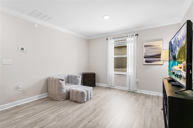 living area featuring ornamental molding, light hardwood / wood-style floors, and a textured ceiling