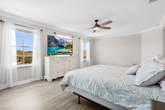 bedroom with light hardwood / wood-style flooring, ceiling fan, and crown molding