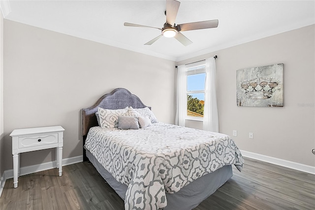 bedroom featuring dark wood-type flooring, ceiling fan, and ornamental molding