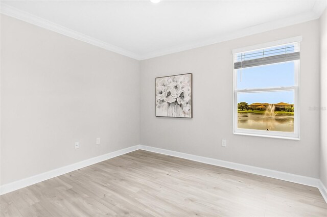 spare room with light wood-type flooring and ornamental molding