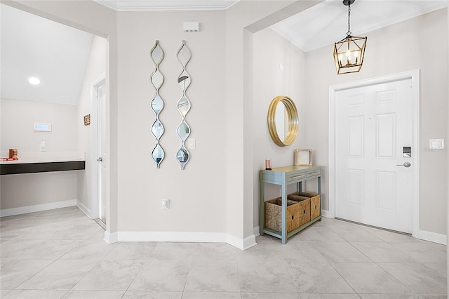 tiled foyer with a notable chandelier, lofted ceiling, and crown molding