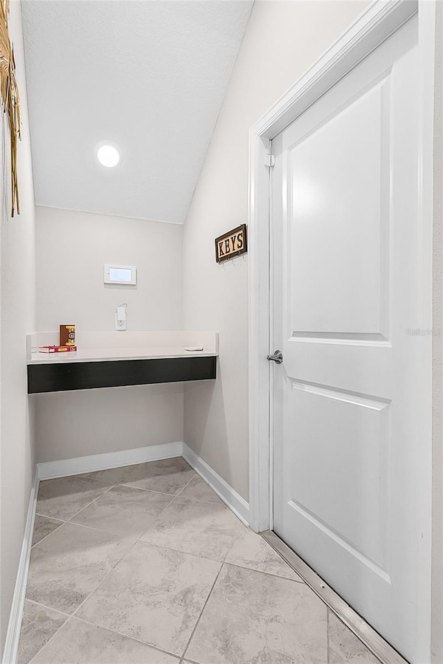 interior space featuring lofted ceiling and light tile patterned floors