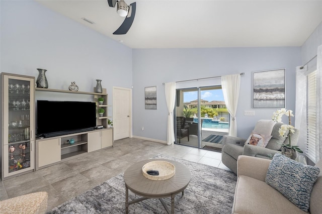 tiled living room with ceiling fan and vaulted ceiling