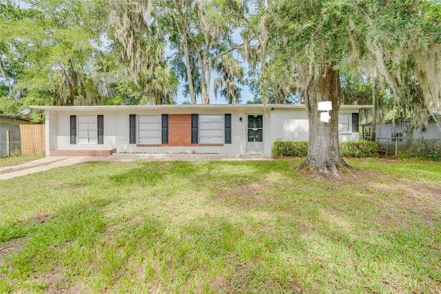 ranch-style home with brick siding, a front yard, and fence