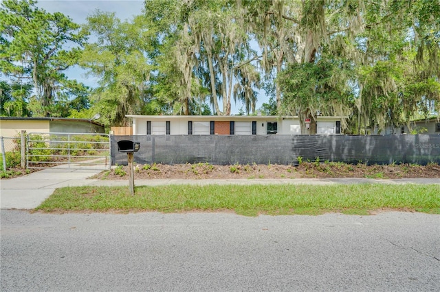 ranch-style home with a gate and fence