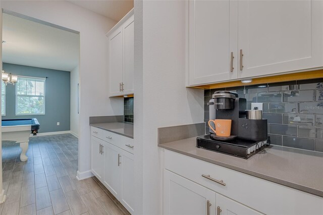 kitchen with white cabinetry, tasteful backsplash, and light hardwood / wood-style flooring