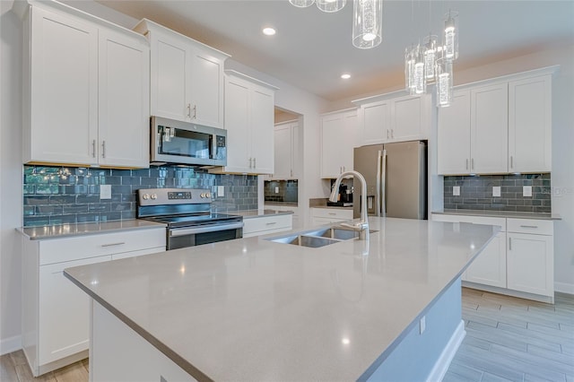 kitchen with hanging light fixtures, sink, decorative backsplash, and stainless steel appliances