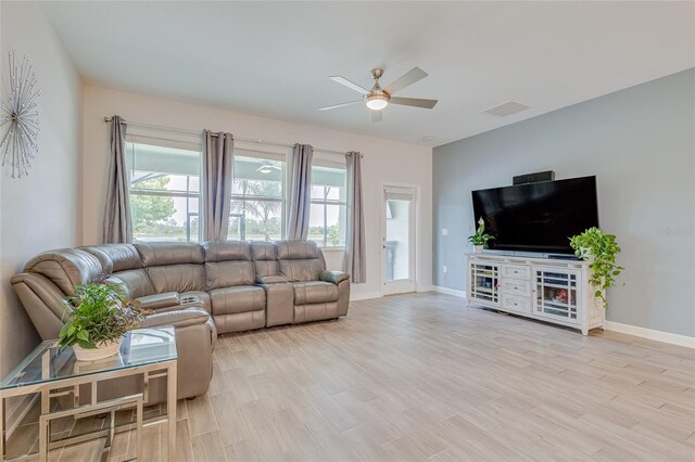 living room featuring plenty of natural light, ceiling fan, and light hardwood / wood-style flooring