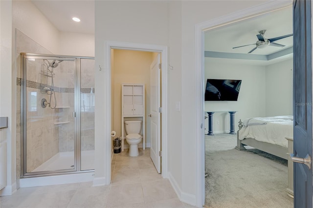 bathroom with a shower with shower door, tile patterned flooring, ceiling fan, and toilet