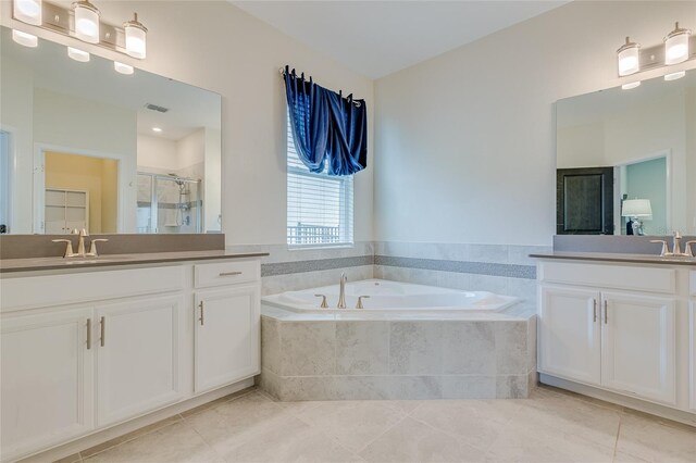 bathroom with vanity, tiled tub, and tile patterned floors