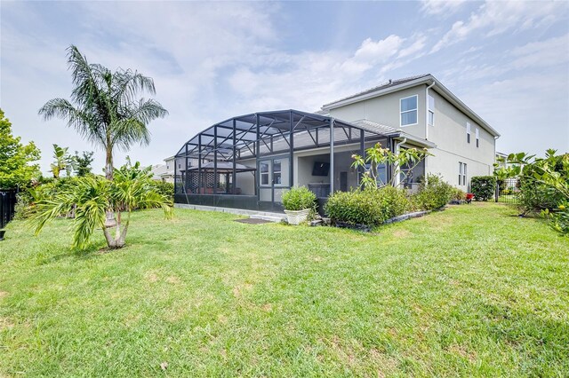 rear view of property featuring a lanai and a yard