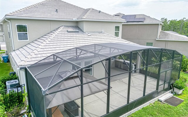 exterior space featuring glass enclosure and central AC unit