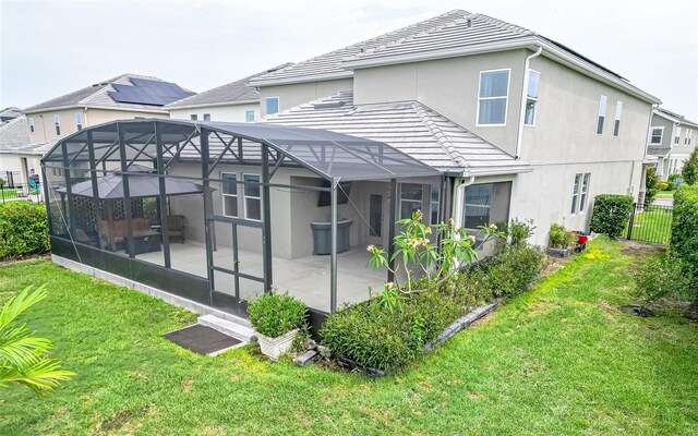 back of property featuring a patio, a lawn, and a lanai