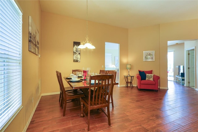 dining room with dark wood-type flooring, a chandelier, and a healthy amount of sunlight