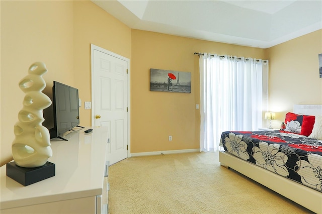 carpeted bedroom with a tray ceiling