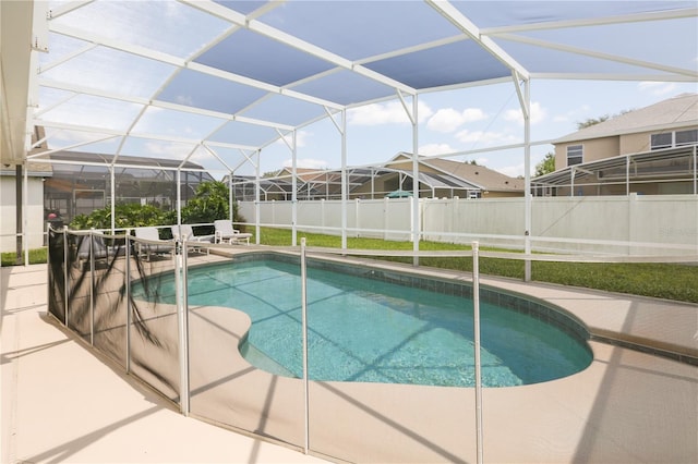 view of swimming pool featuring a patio area and glass enclosure