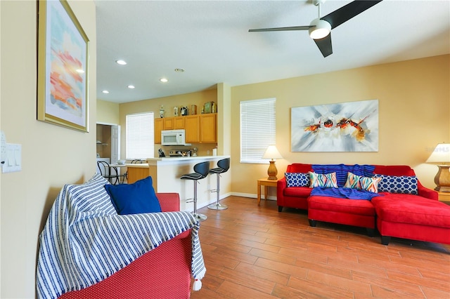 living room featuring ceiling fan and light wood-type flooring