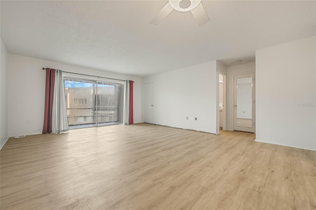 empty room with ceiling fan, a textured ceiling, and light hardwood / wood-style flooring