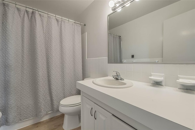 bathroom with wood-type flooring, tile walls, vanity, walk in shower, and toilet