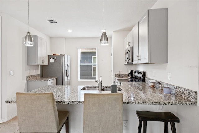 kitchen with appliances with stainless steel finishes, a kitchen bar, and kitchen peninsula