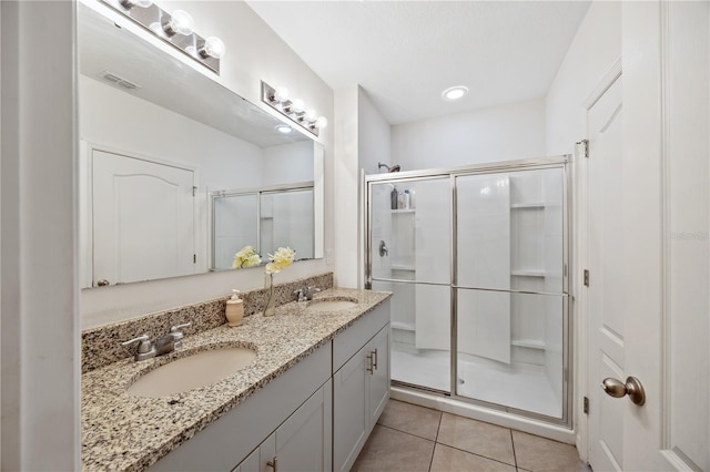 bathroom with tile patterned floors, an enclosed shower, and vanity