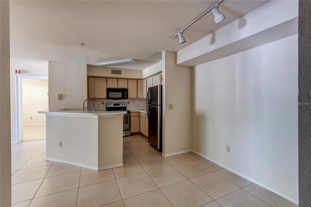 kitchen featuring light tile patterned floors, appliances with stainless steel finishes, rail lighting, and kitchen peninsula