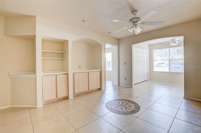 interior space with light tile patterned flooring, a textured ceiling, and ceiling fan