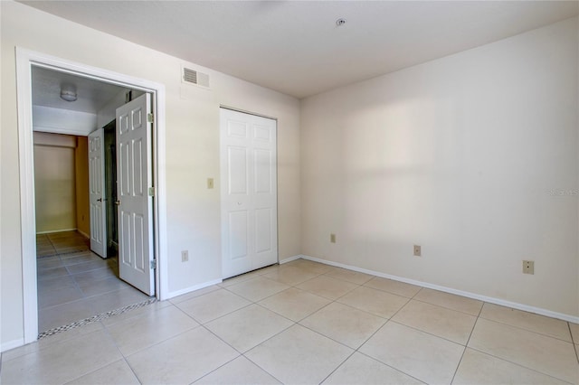 unfurnished bedroom featuring a closet and light tile patterned floors