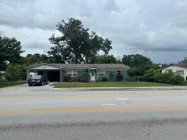 view of front of home with an attached carport, driveway, and a front yard