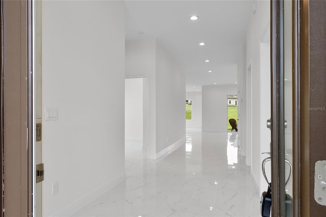 corridor with recessed lighting, marble finish floor, and baseboards