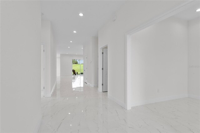 corridor with recessed lighting, marble finish floor, and baseboards