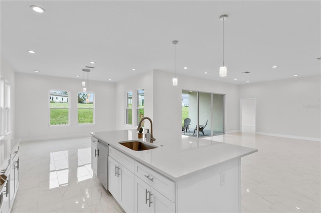 kitchen featuring white cabinetry, sink, pendant lighting, and a center island with sink