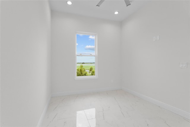 spare room featuring recessed lighting, marble finish floor, and baseboards